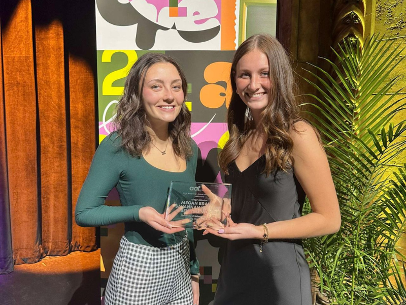 Two women pose with award